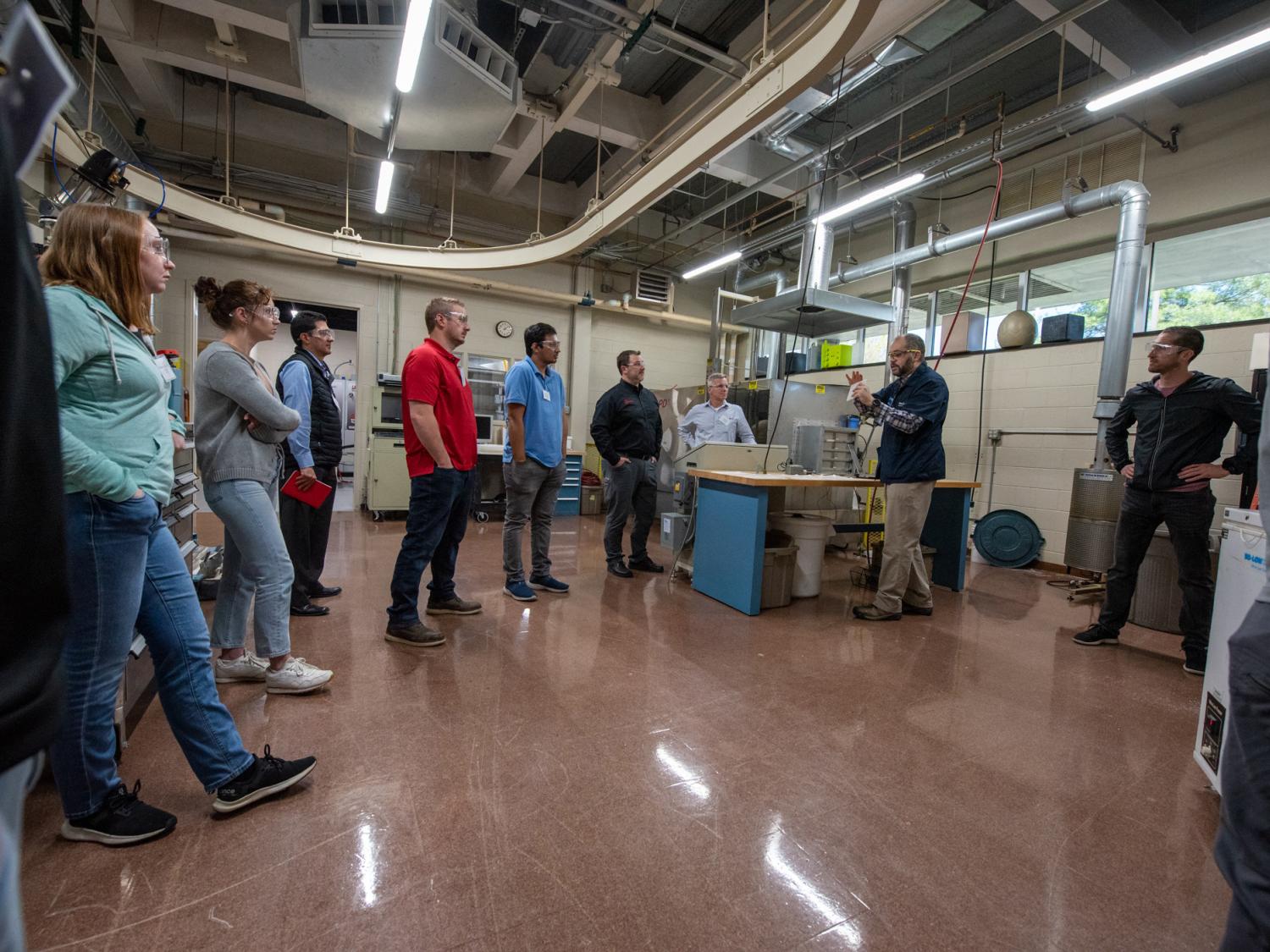 people standing in a large workshop area