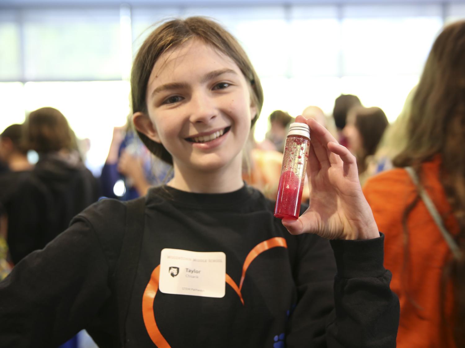 A girl holds a test tube.