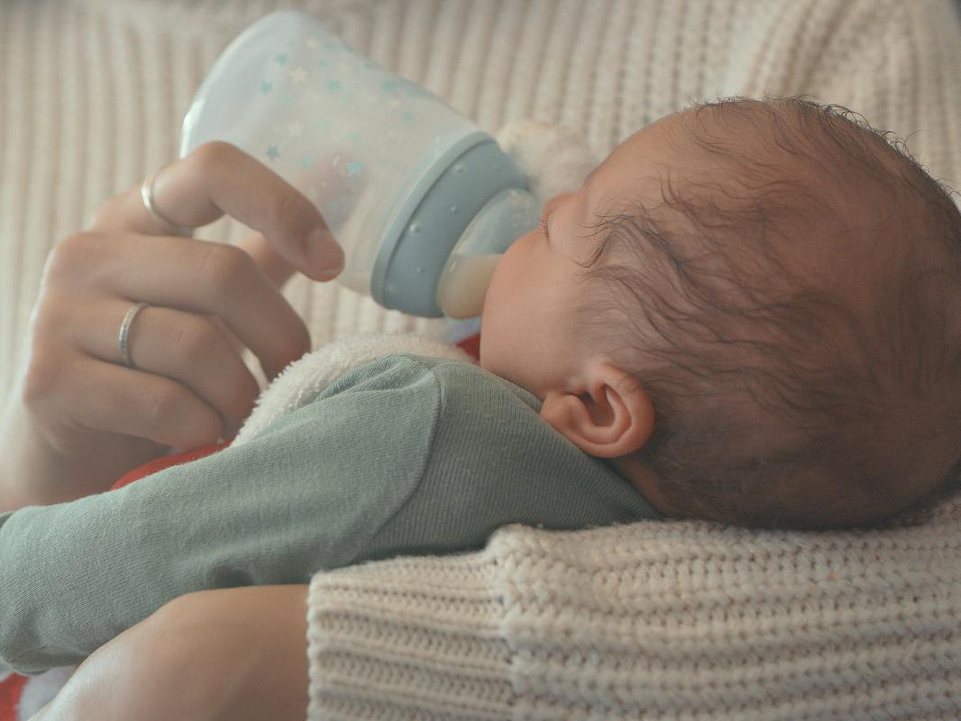 A mother feeds her newborn son.