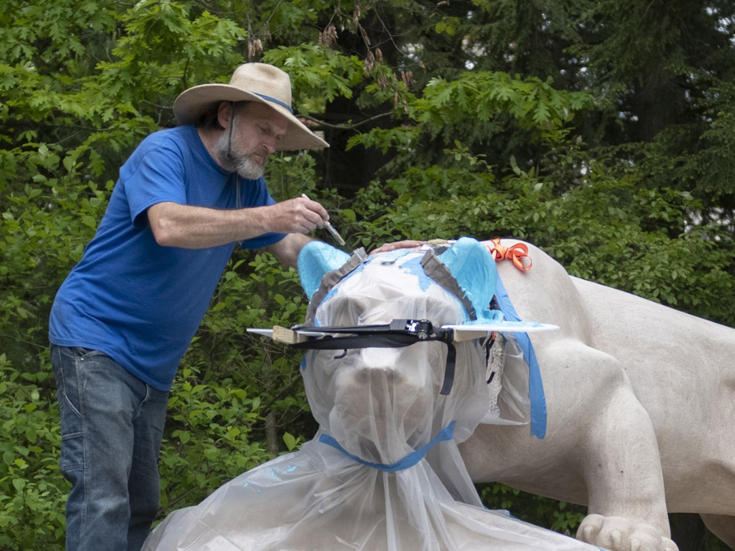 Curtis Martin, a stone sculptor and conservator with McKay Lodge Conservation Laboratory, carefully applies casting to both ears on the Nittany Lion Shrine.