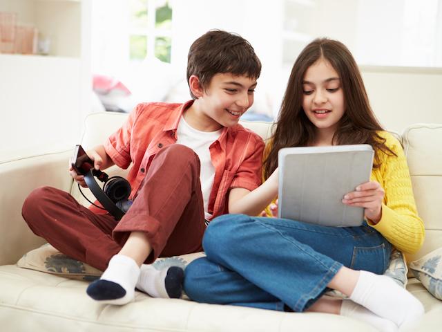 Latino siblings playing with MP3 player.