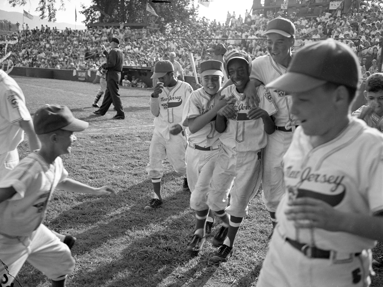 A black and white image of Little League baseball players on a field