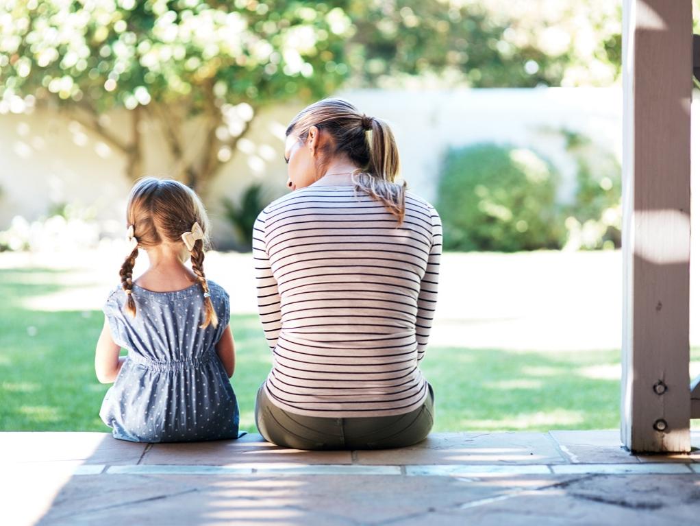 Rearview shot of a young woman and her daughter having a conversation on the porch.