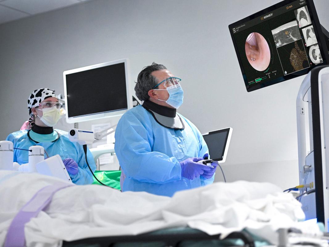 A physician looks at a screen while performing a bronchoscopy 