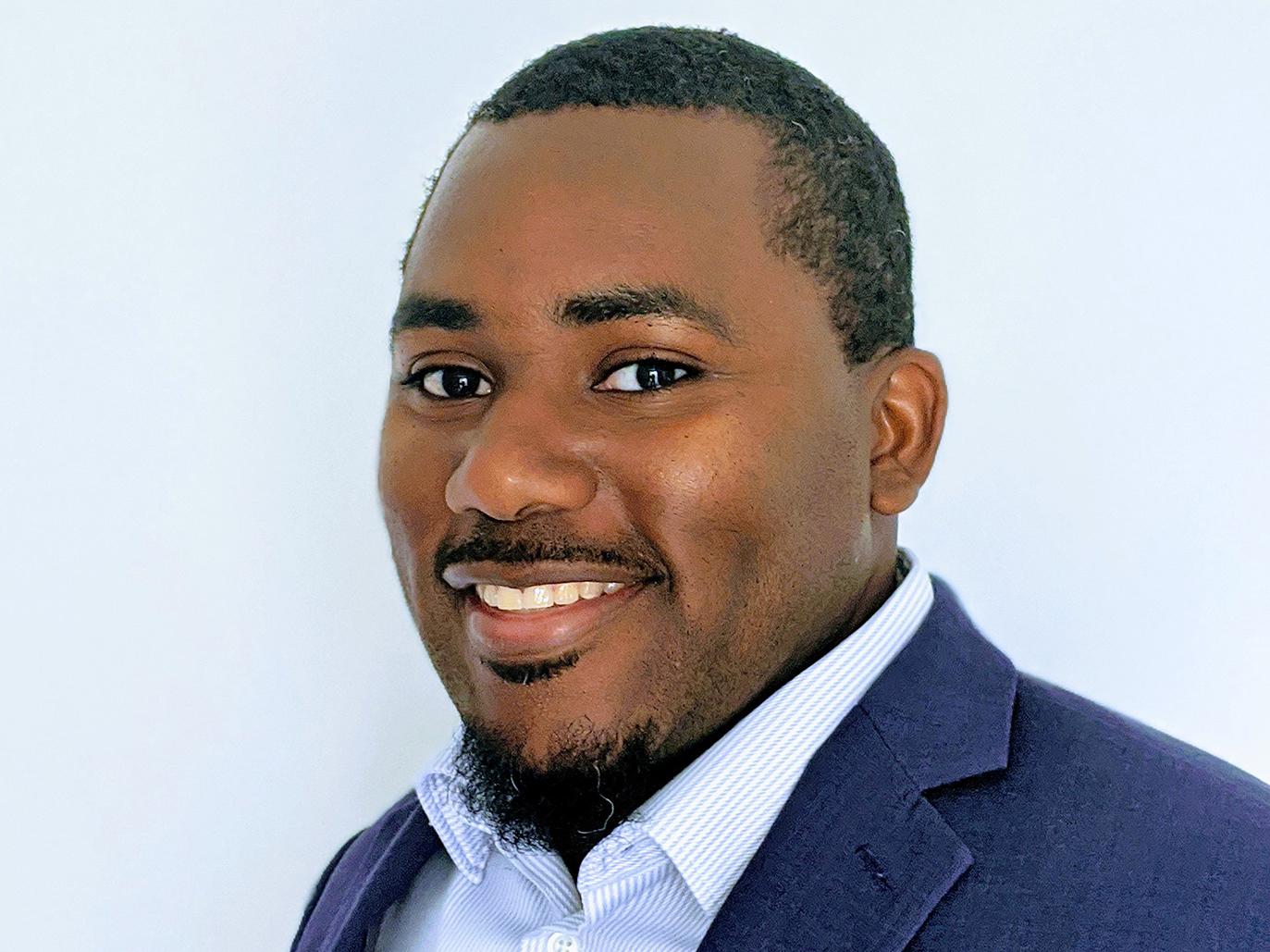 A headshot photo of Nathaniel E. Woods Jr. wearing a blue suit jacket and white shirt