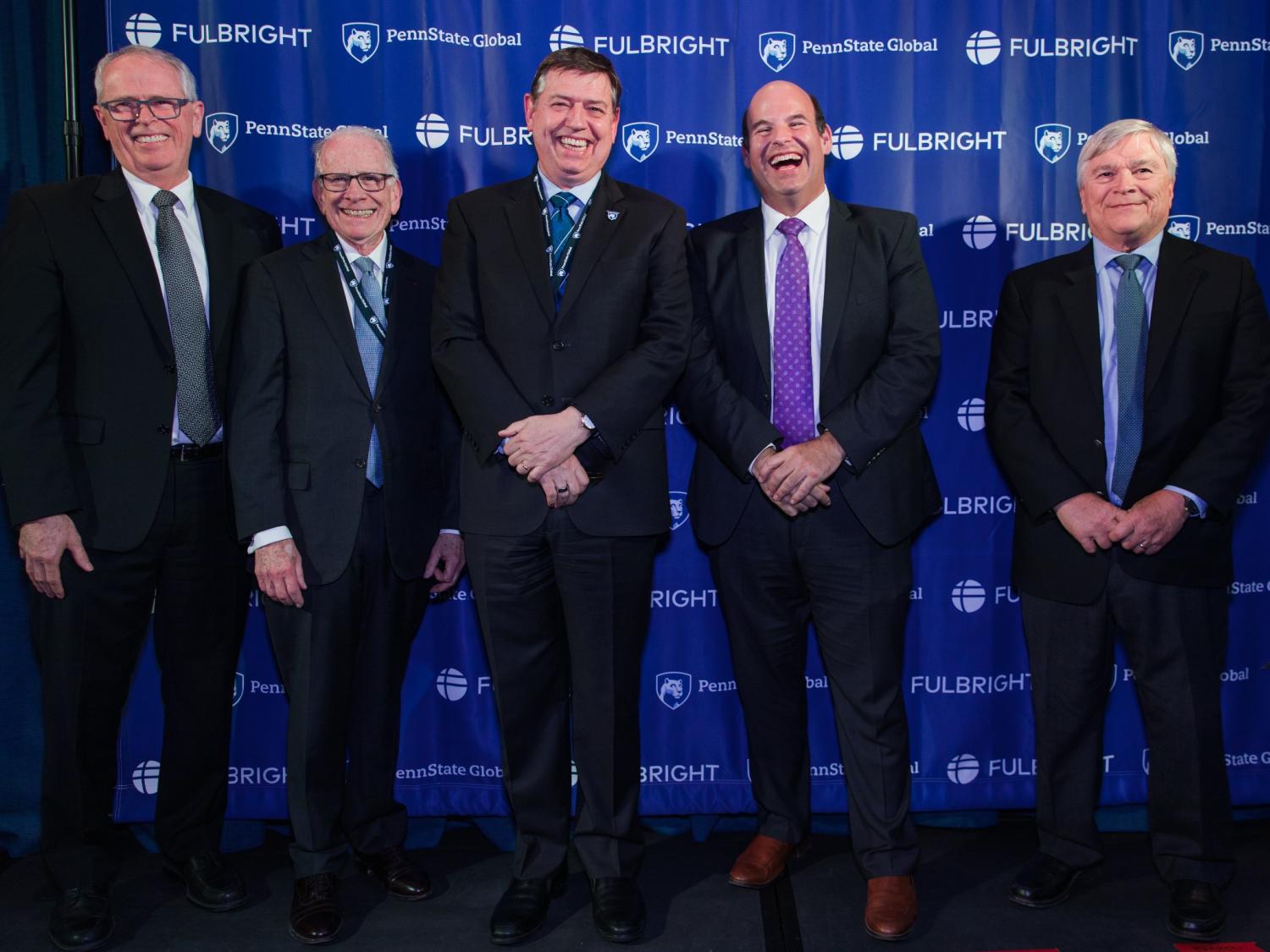 Five men standing in front of a Penn State and Fulbright Banner