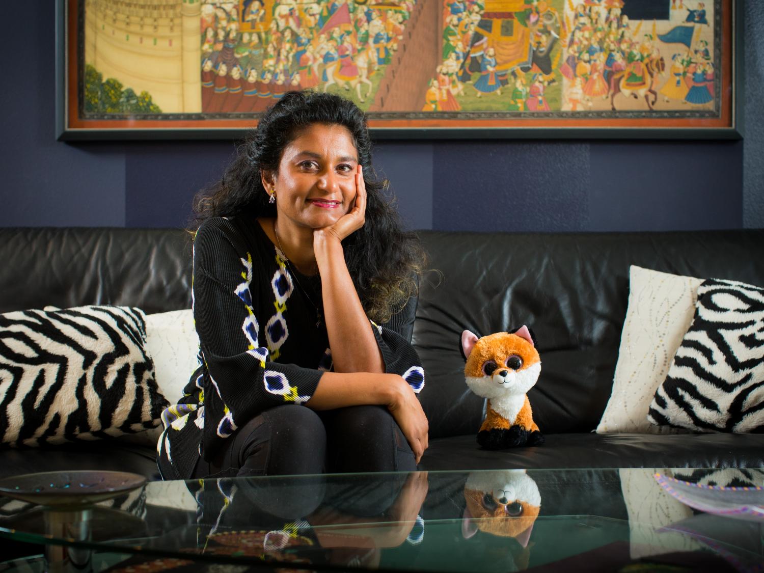Headshot of Swatee Surve sitting on a couch with stuffed animal Socks the Fox