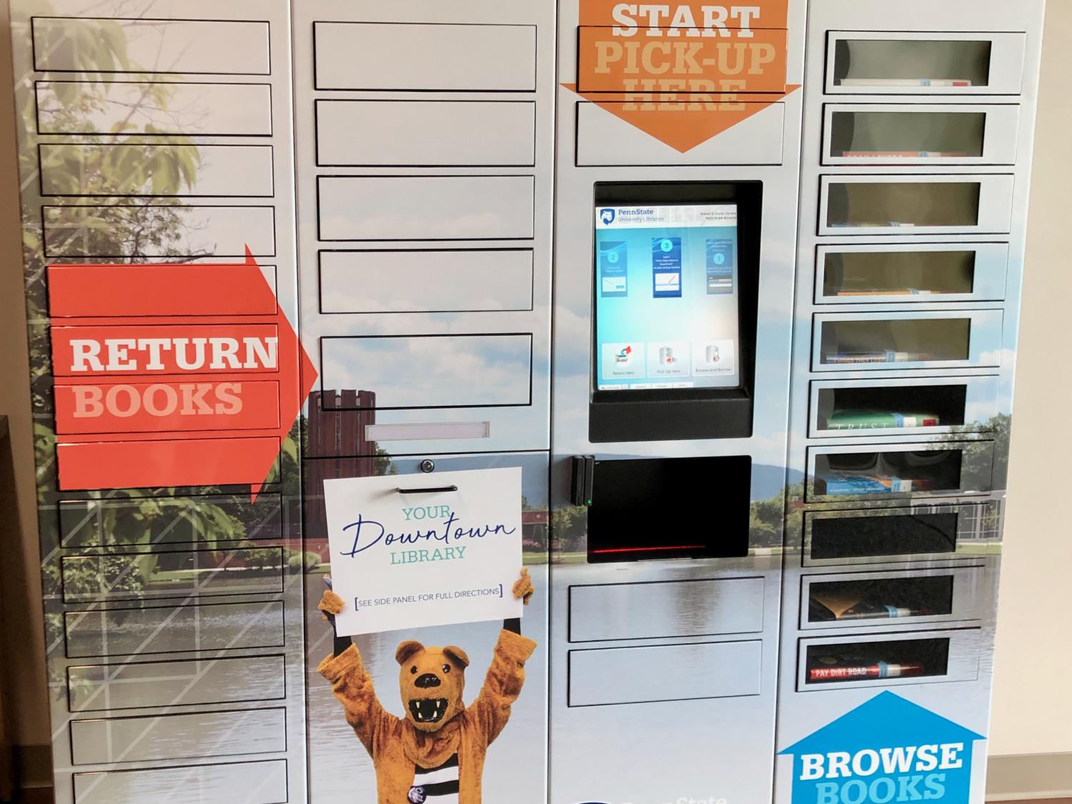 tall metal locker system with central touchscreen and dozens of small narrow doors, some with windows to see book covers