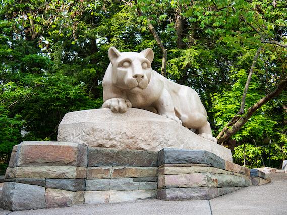 A statue in the shape of a mountain lion sitting atop rocks