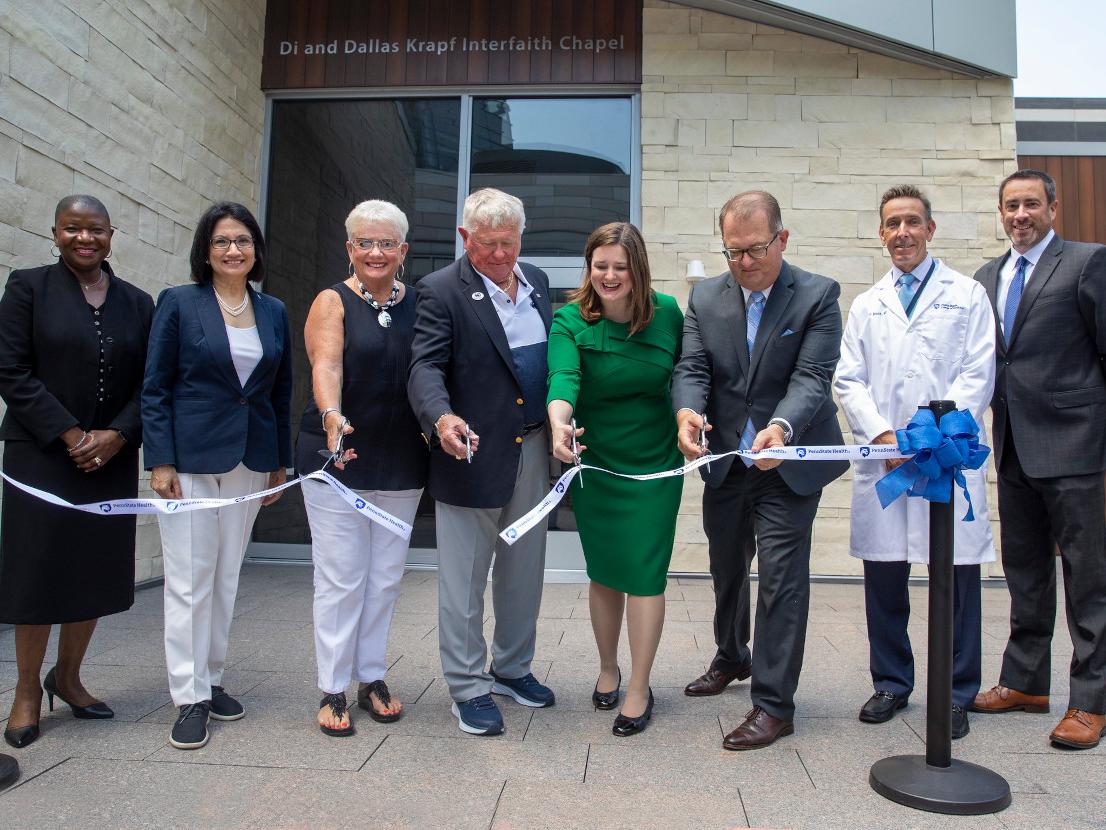 A group of people cut a ribbon outside of the new interfaith chapel