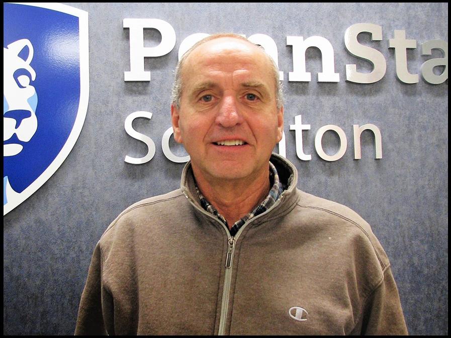 headshot of Jake Hinton standing in front of Penn State Scranton wall