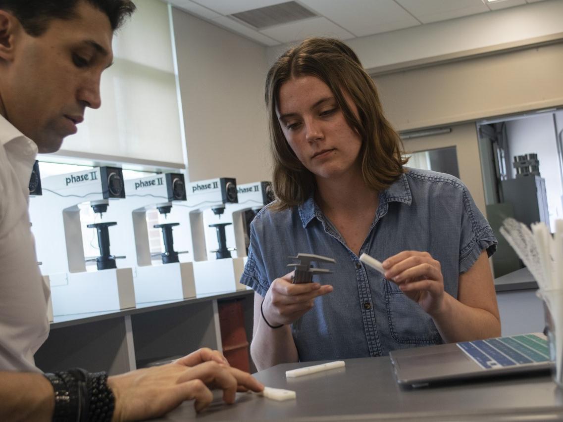 A man and a woman measuring samples in the lab