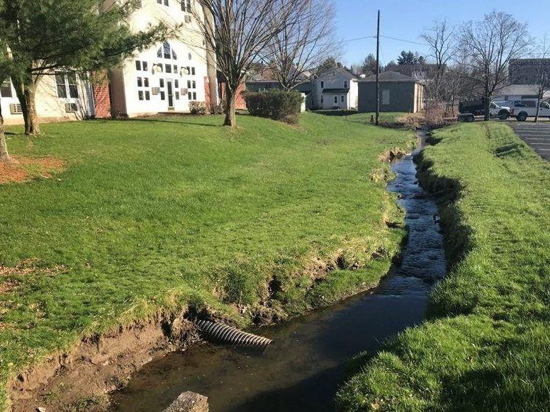 A stream flows through the backyard of a residential property