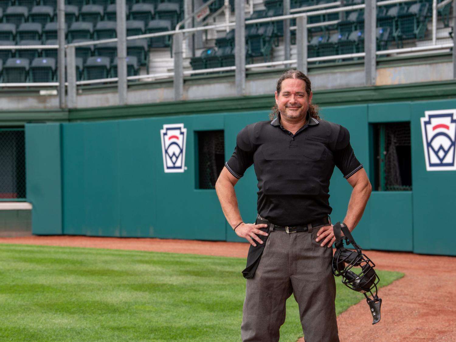 Craig A. Miller standing in stadium with umpire uniform
