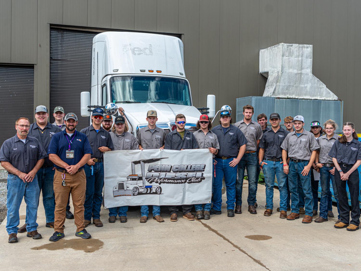 People standing next to a donated semi-trailer truck