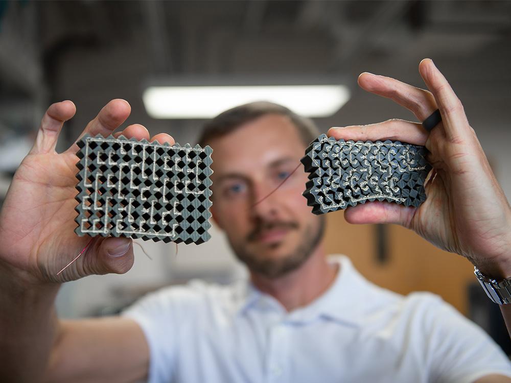 man holds rubber block in one hand and squeezed rubber block in other hand