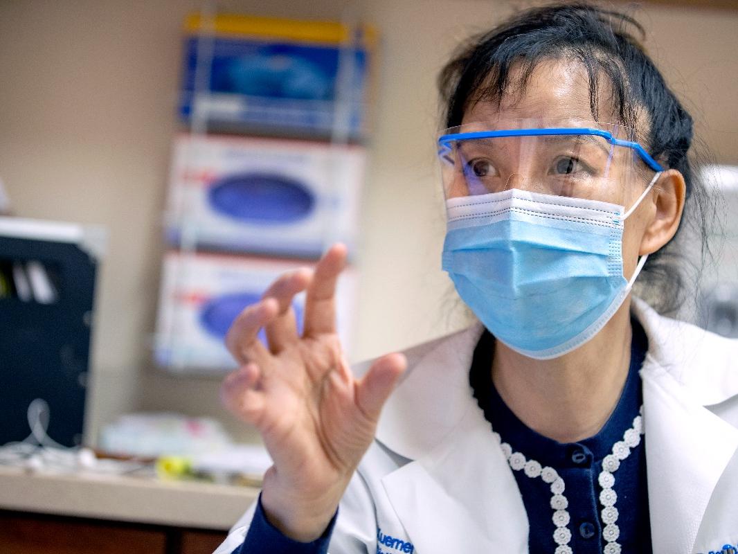 Dr. Xuemei Huang talks with a patient at Penn State Health Milton S. Hershey Medical Center.