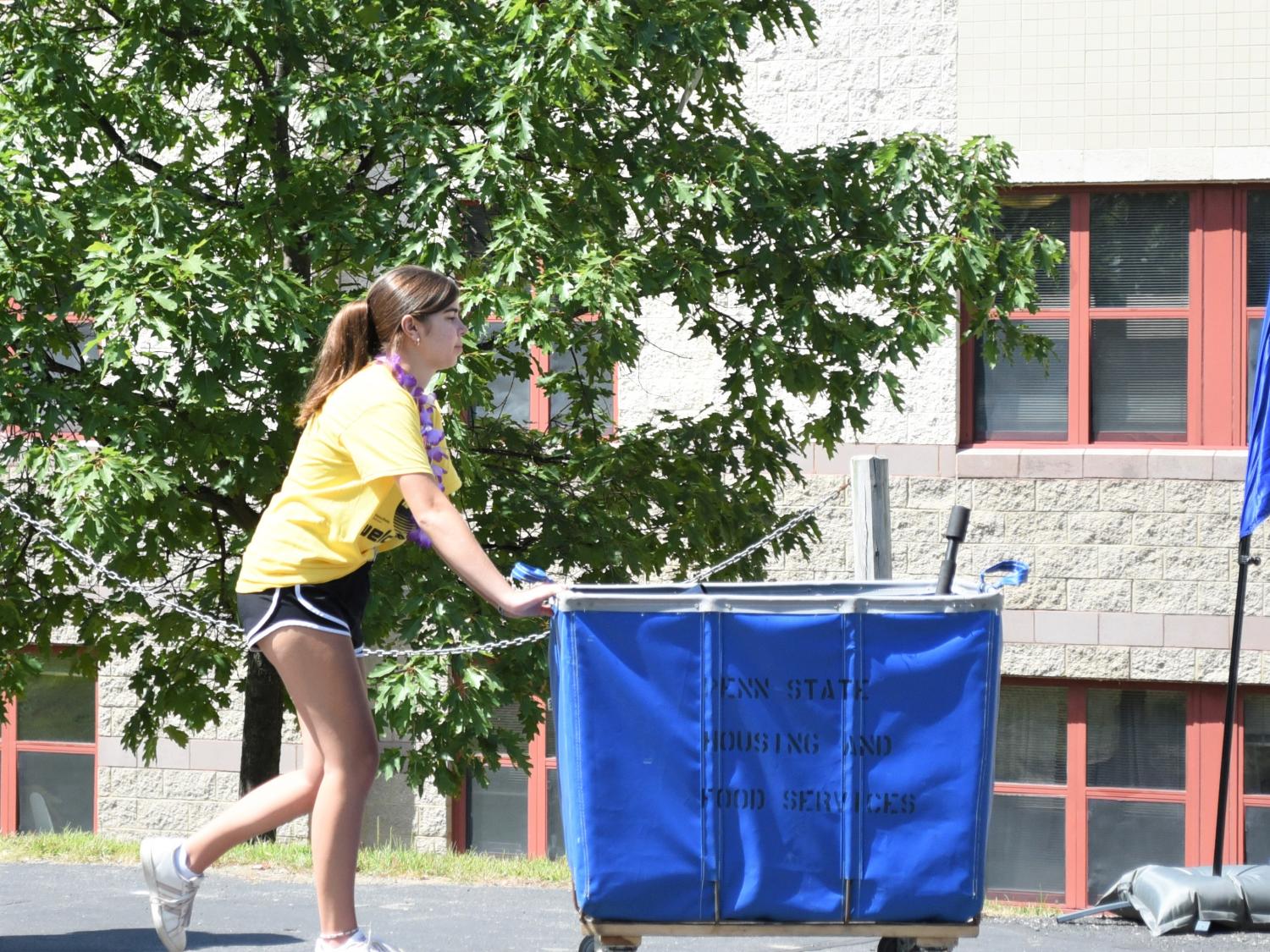 A female student pushes a luggage cart during Penn State Behrend's move-in day.