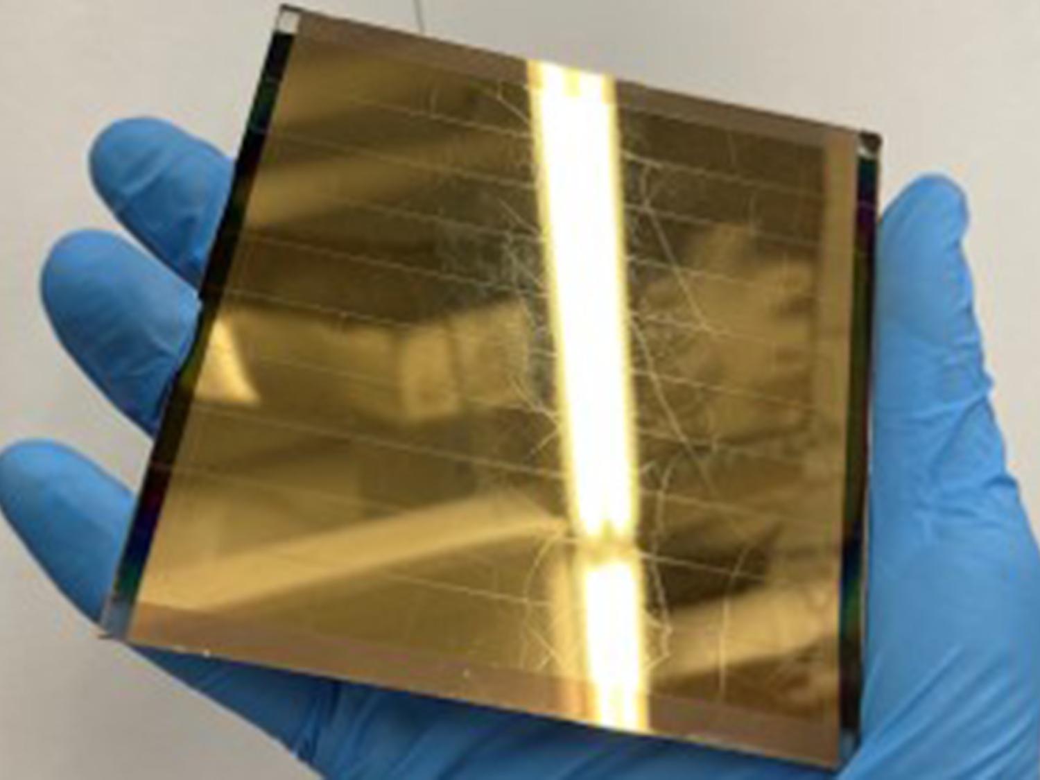 A researcher holds a perovskite solar module  