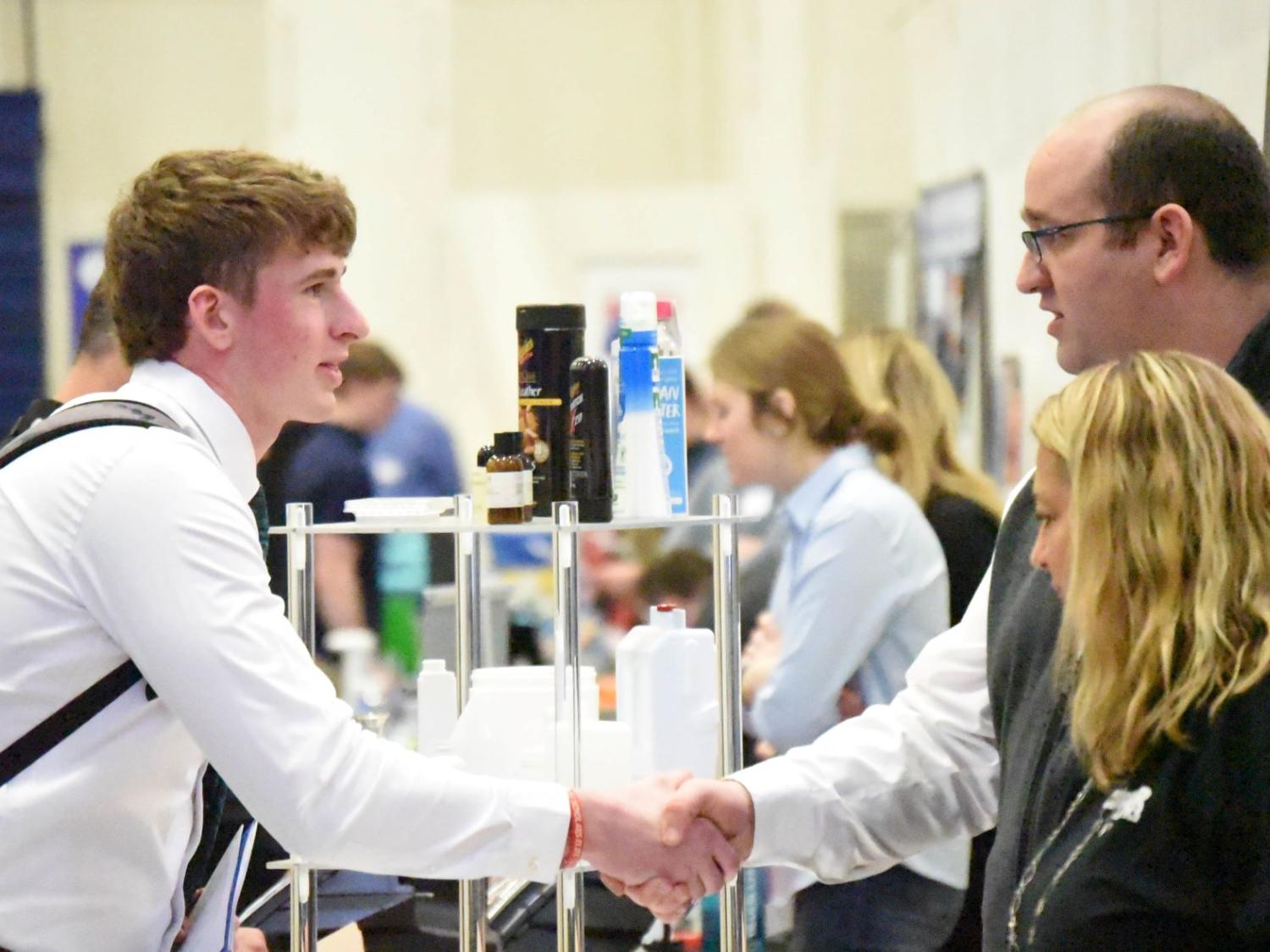 A student shakes hands with a corporate recruiter at Penn State Behrend's Career and Internship Fair.