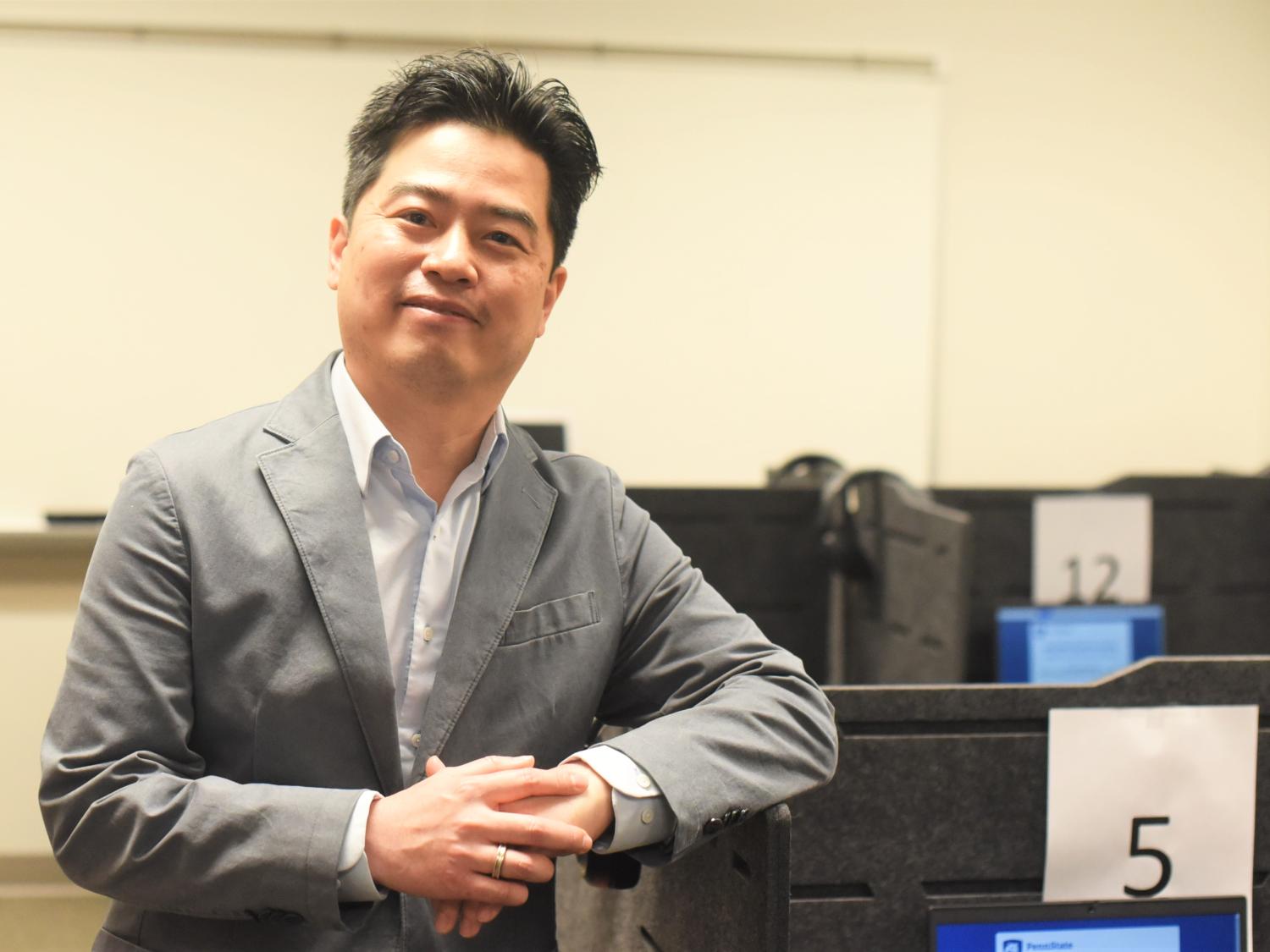 A Penn State Behrend faculty member poses near a computer workstation in the college's Raimy Behavioral Lab.
