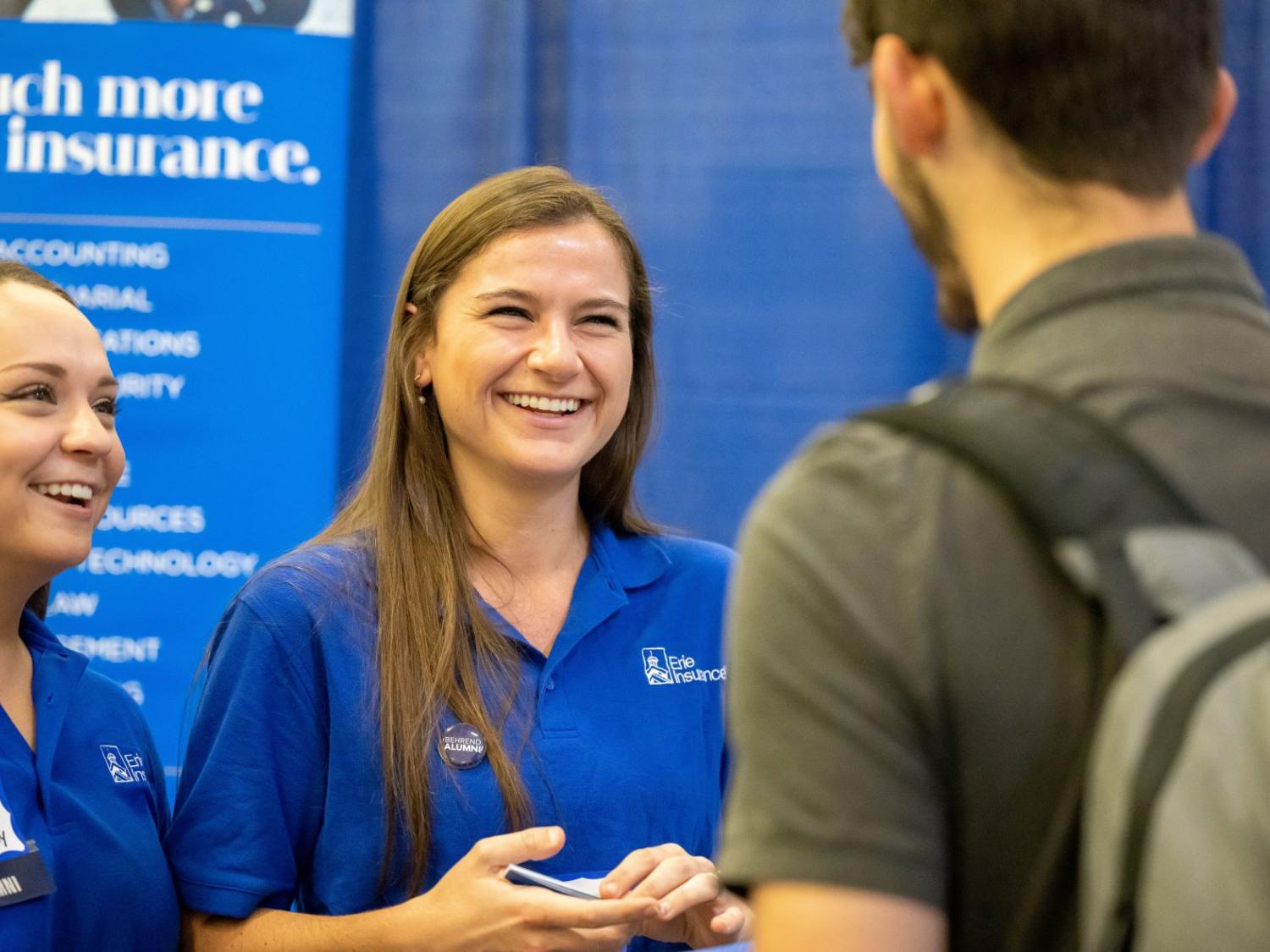 Two female corporate recruiters talk with a student during Penn State Behrend's fall career fair.