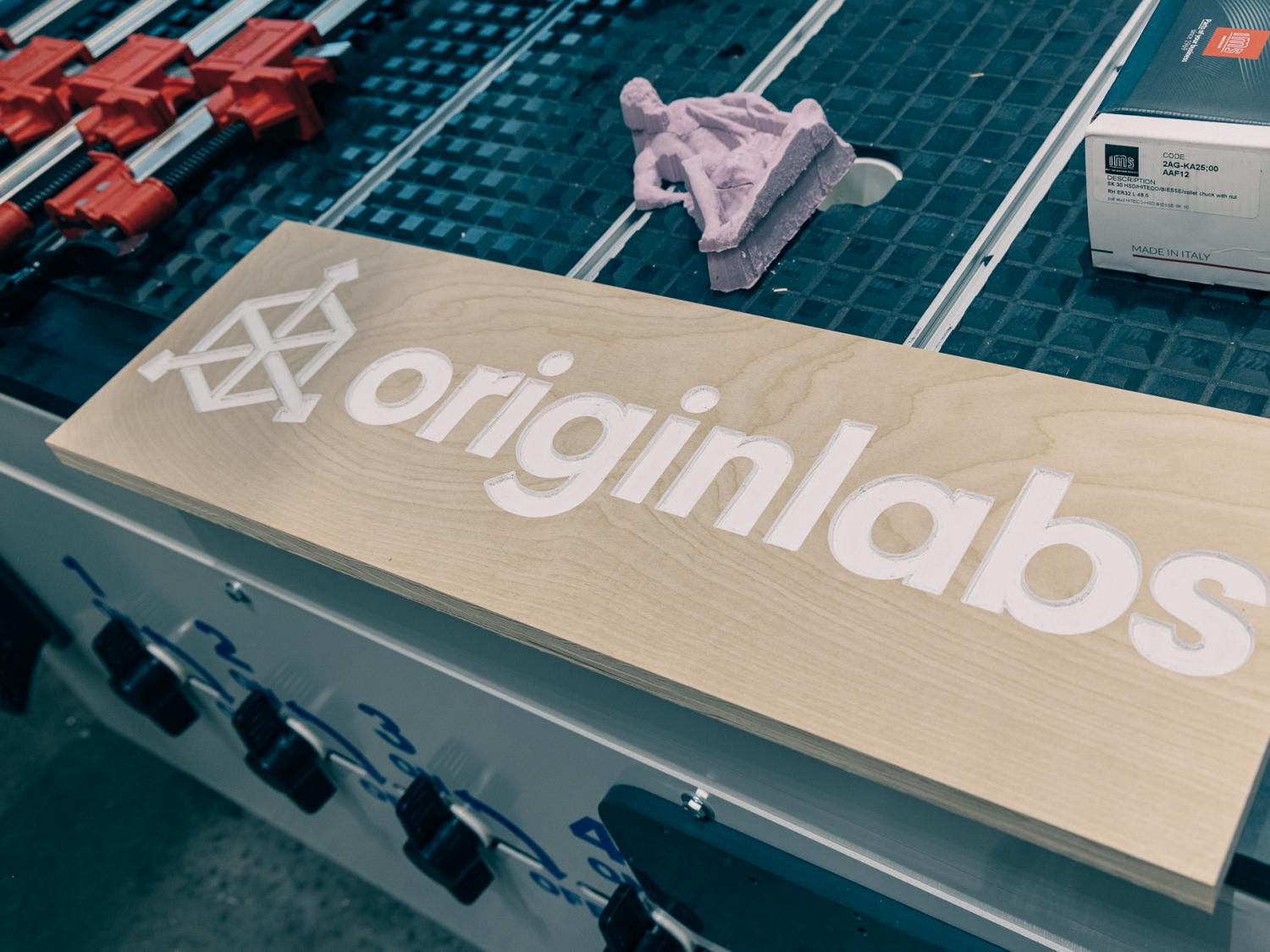 The OriginLabs logo is engraved on a wooden sign