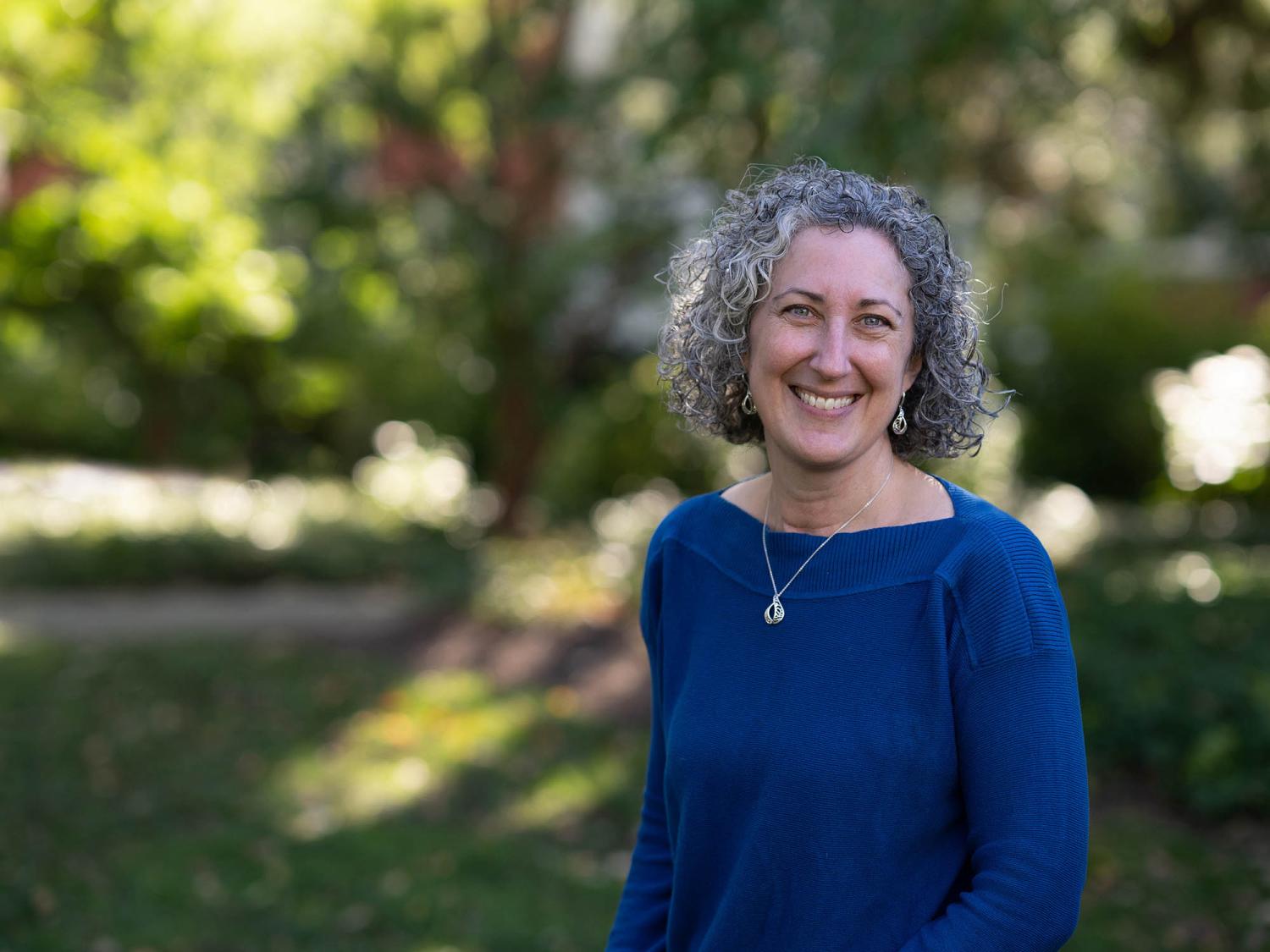photo of smiling woman standing outdoors 