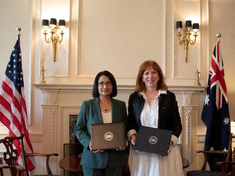 Two women posing with folders