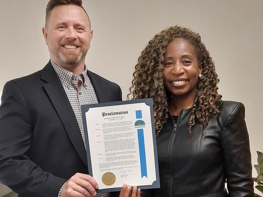 Two people stand with a proclamation. 