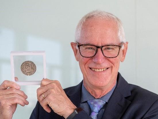 A man holding up a medal