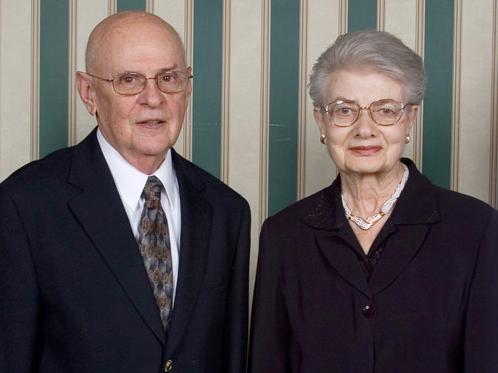 Man and Woman standing side by side in black formal wear.