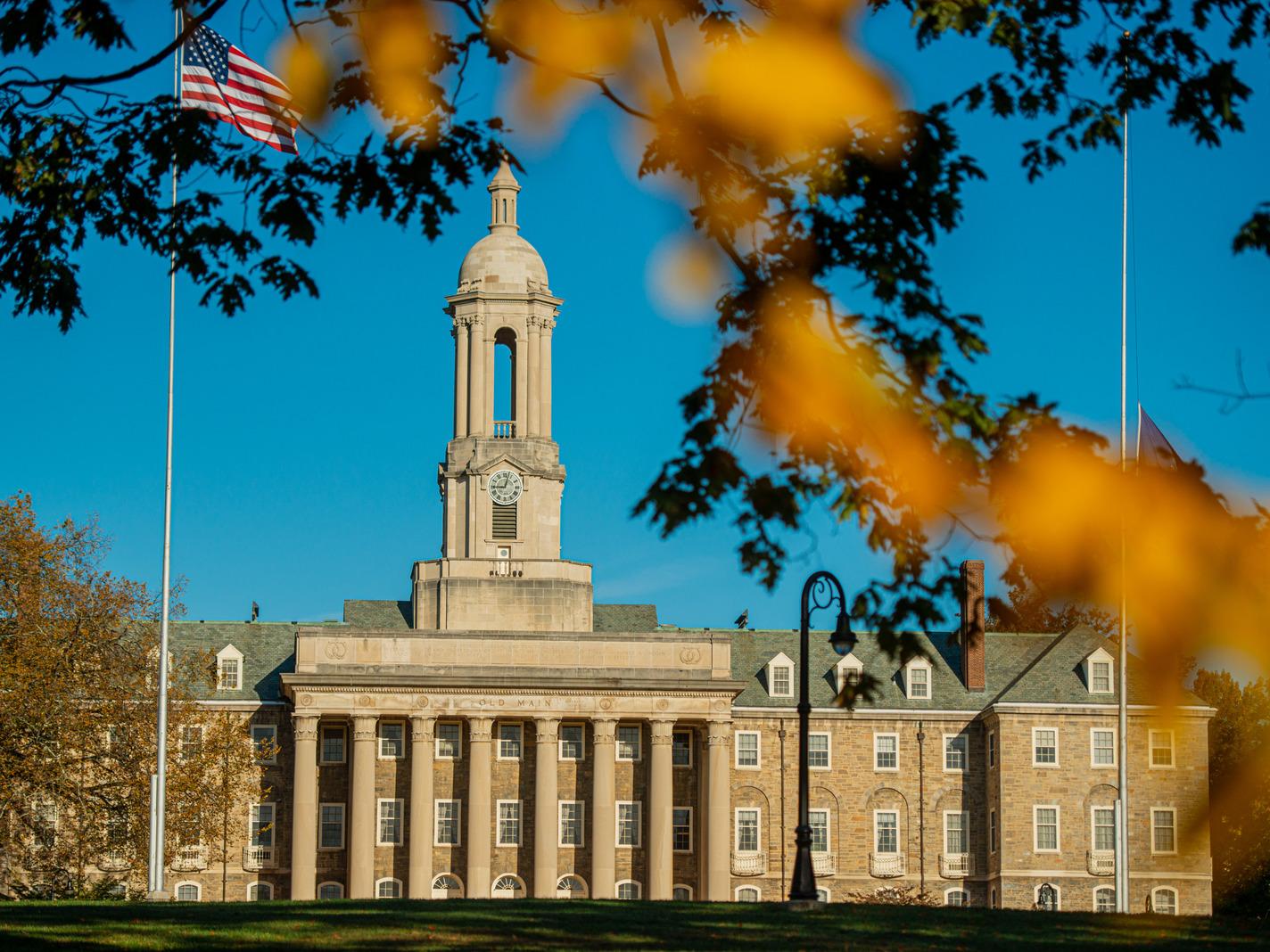 Stone campus building with fall foliage in foreground