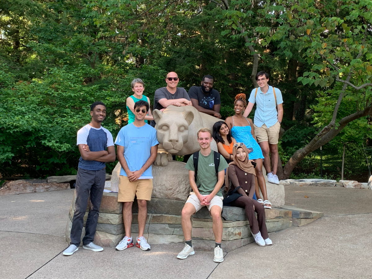 Nine individuals, including student startup founders and Happy Valley LaunchBox powered by PNC Bank mentors, stand at the nittany lion shrine at University Park.