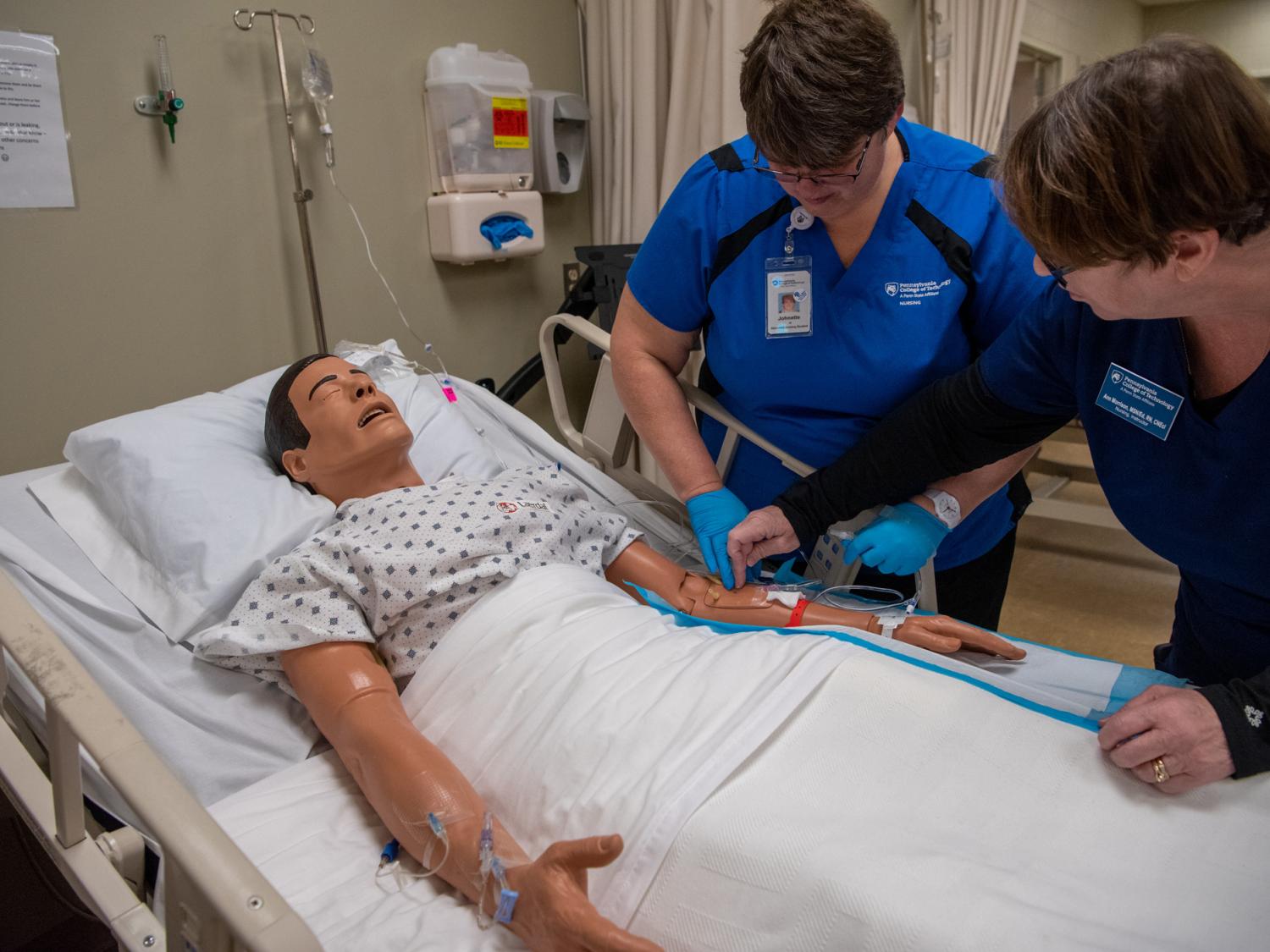 Penn Tech nursing student practices IV insertion alongside instructor 