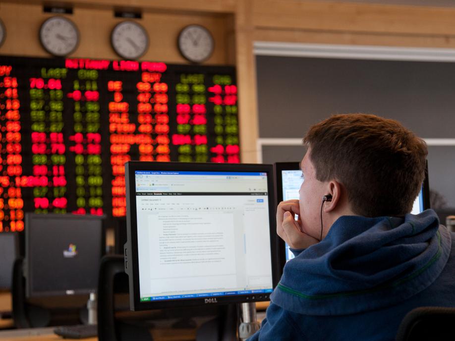 A photo of a student in the trading room in the Business Building