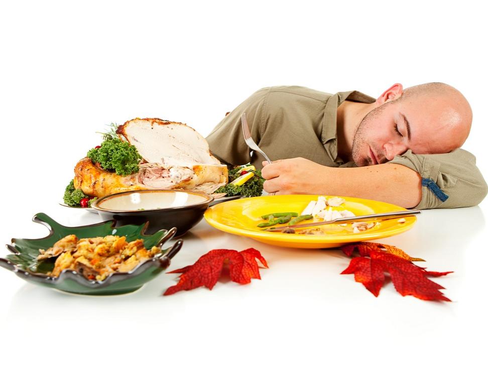 A man falls asleep at the table, amid what’s left of a turkey dinner.