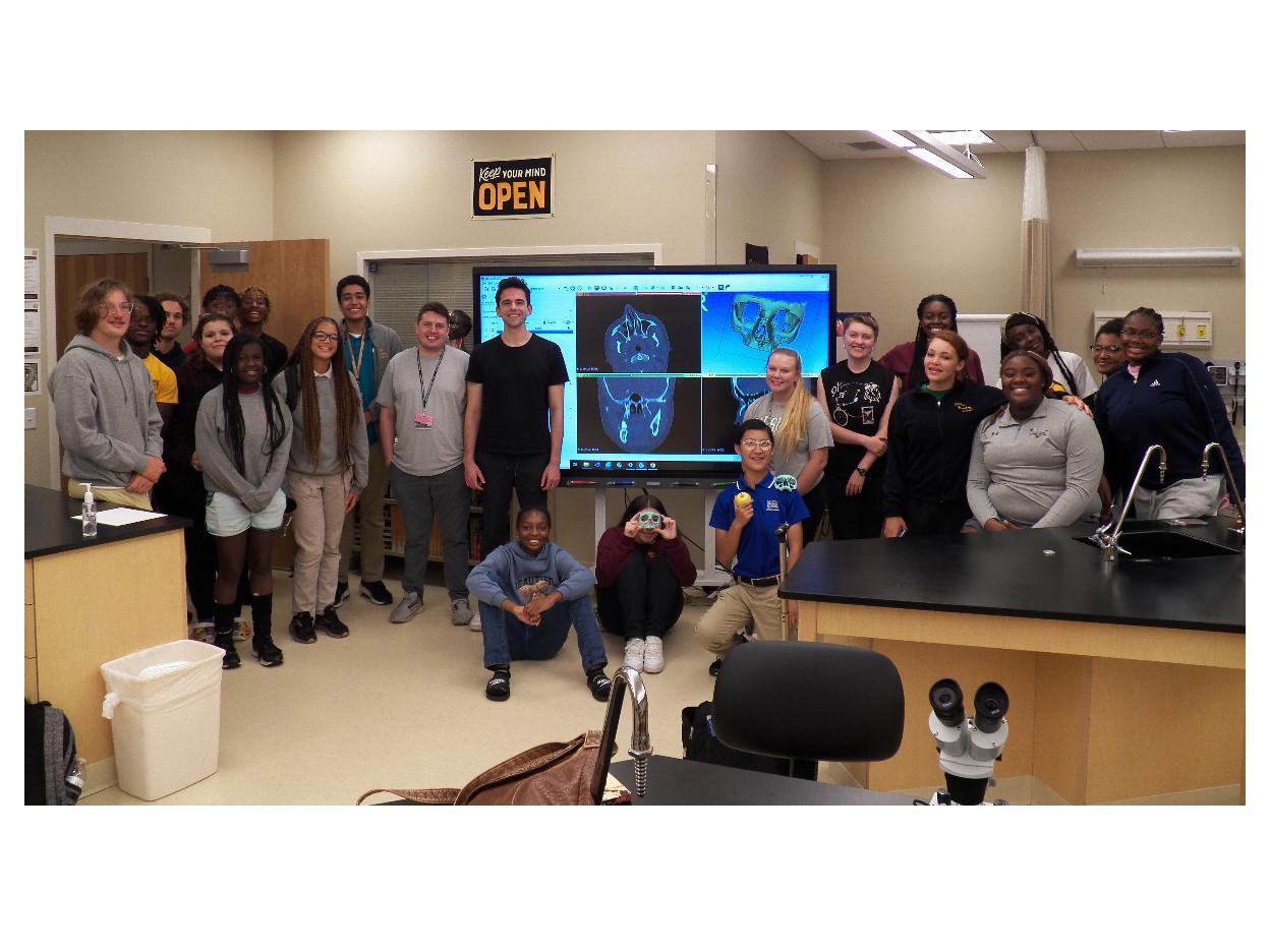 Medical students Marc Levine and Thomas Brouse and Milton Hershey School students pose for a photo while holding facial bone they 3D-printed.