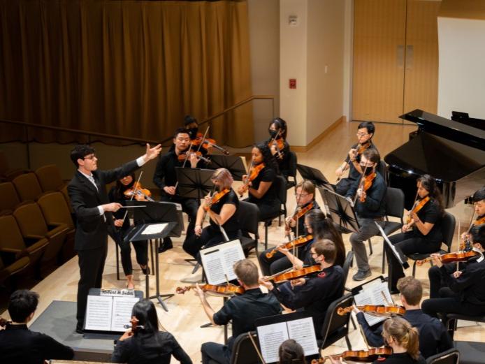Photo of an orchestra with conductor