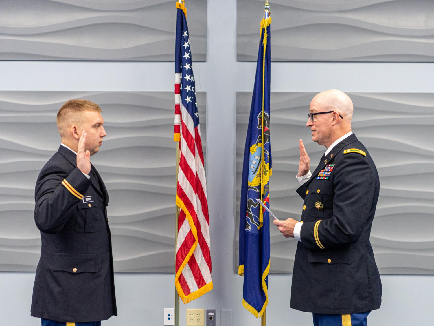 Army ROTC cadet raising right hand to be commissioned at a ceremony. 