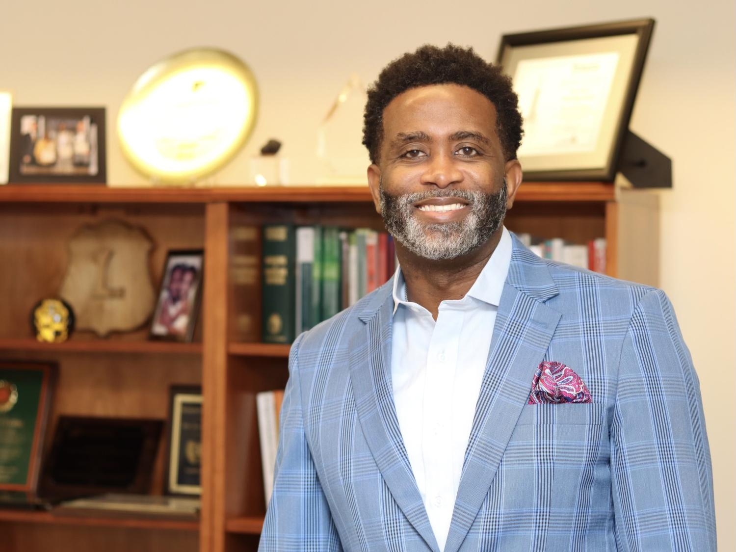 Levon Esters pictured in an office with a bookshelf in the background.