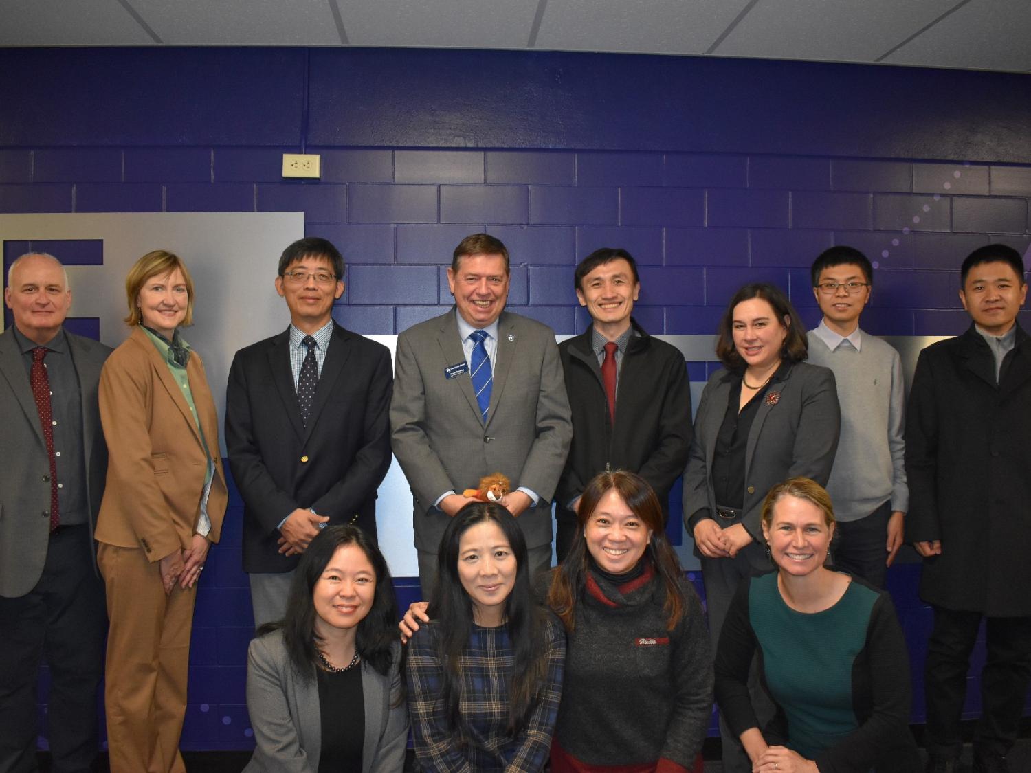 A group of people posing in front of a blue wall