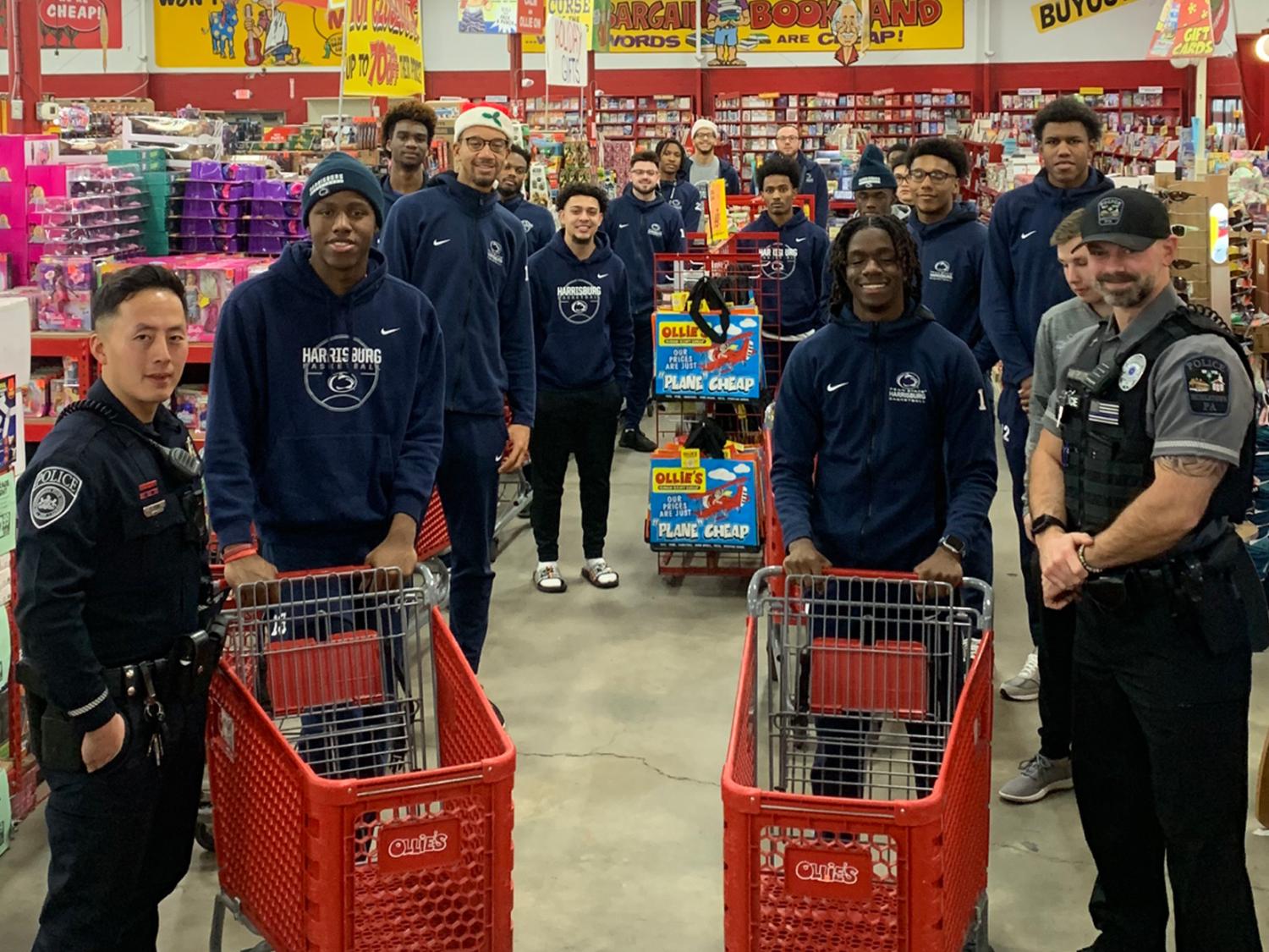 two police officers and several men's basketball players pose with carts in a store