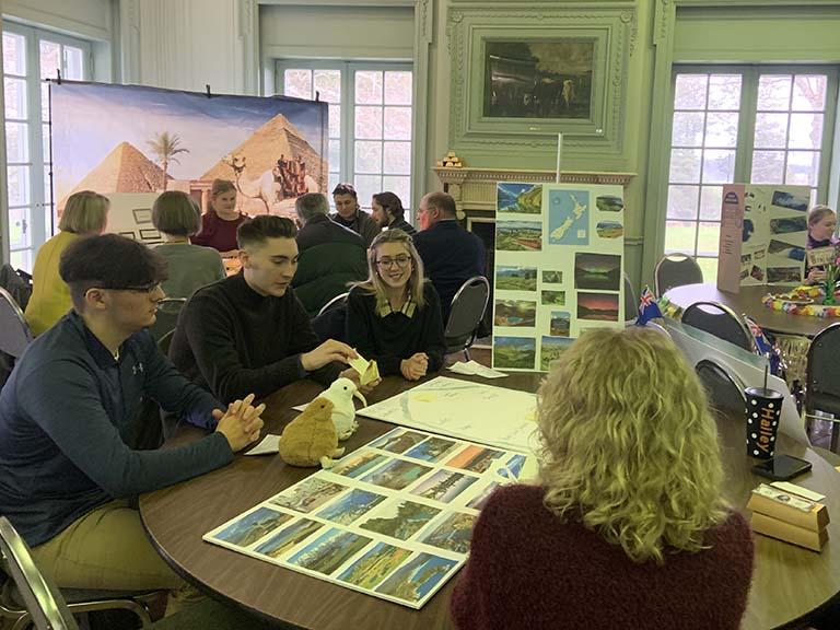 Students seated at a table for presentations.