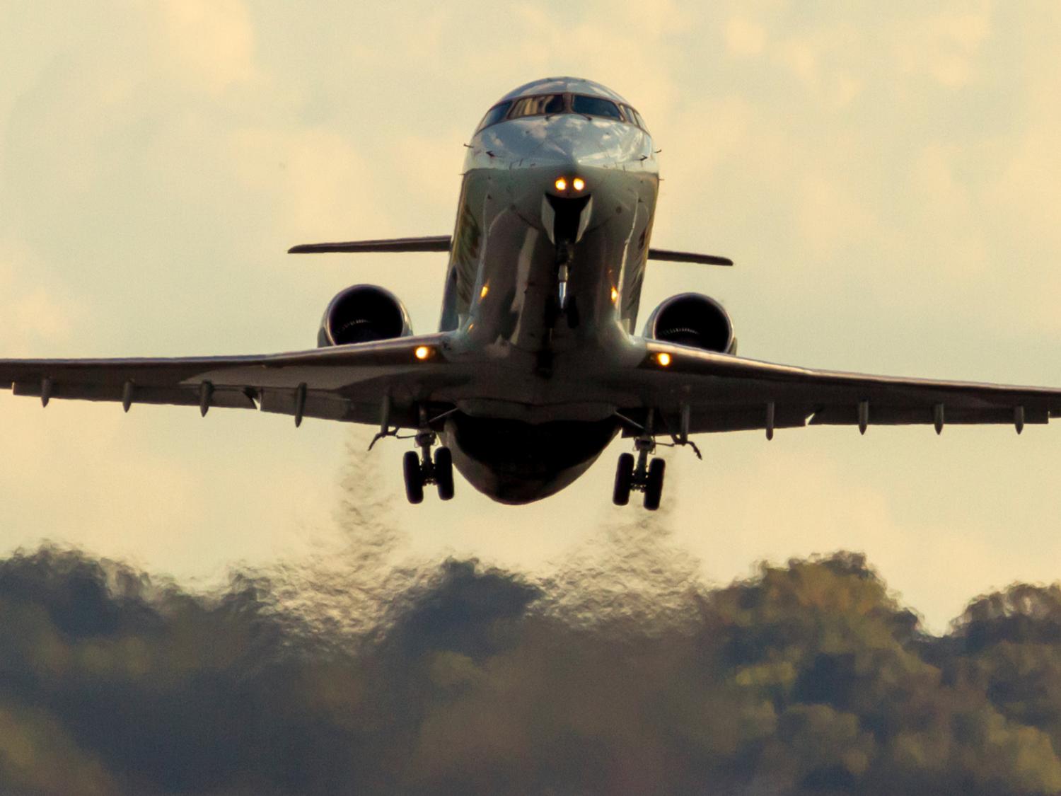 Exhaust pours from the turbines of a jet as it takes off.