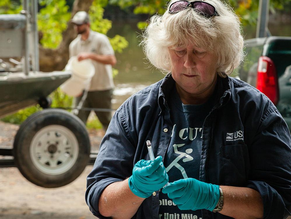 Female biologist with rubber gloves examining a sample.