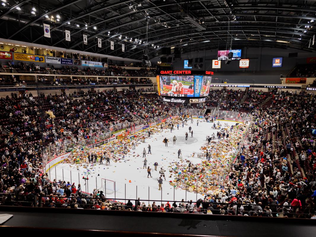 Thousands of teddy bears sit on the ice at an ice hockey game