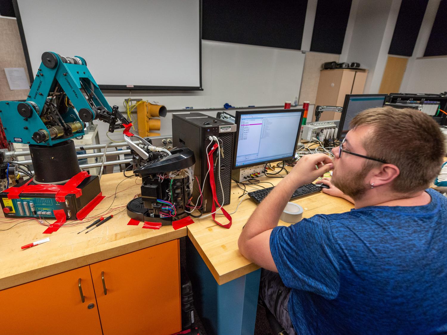 A person working on an electronics project, at a computer