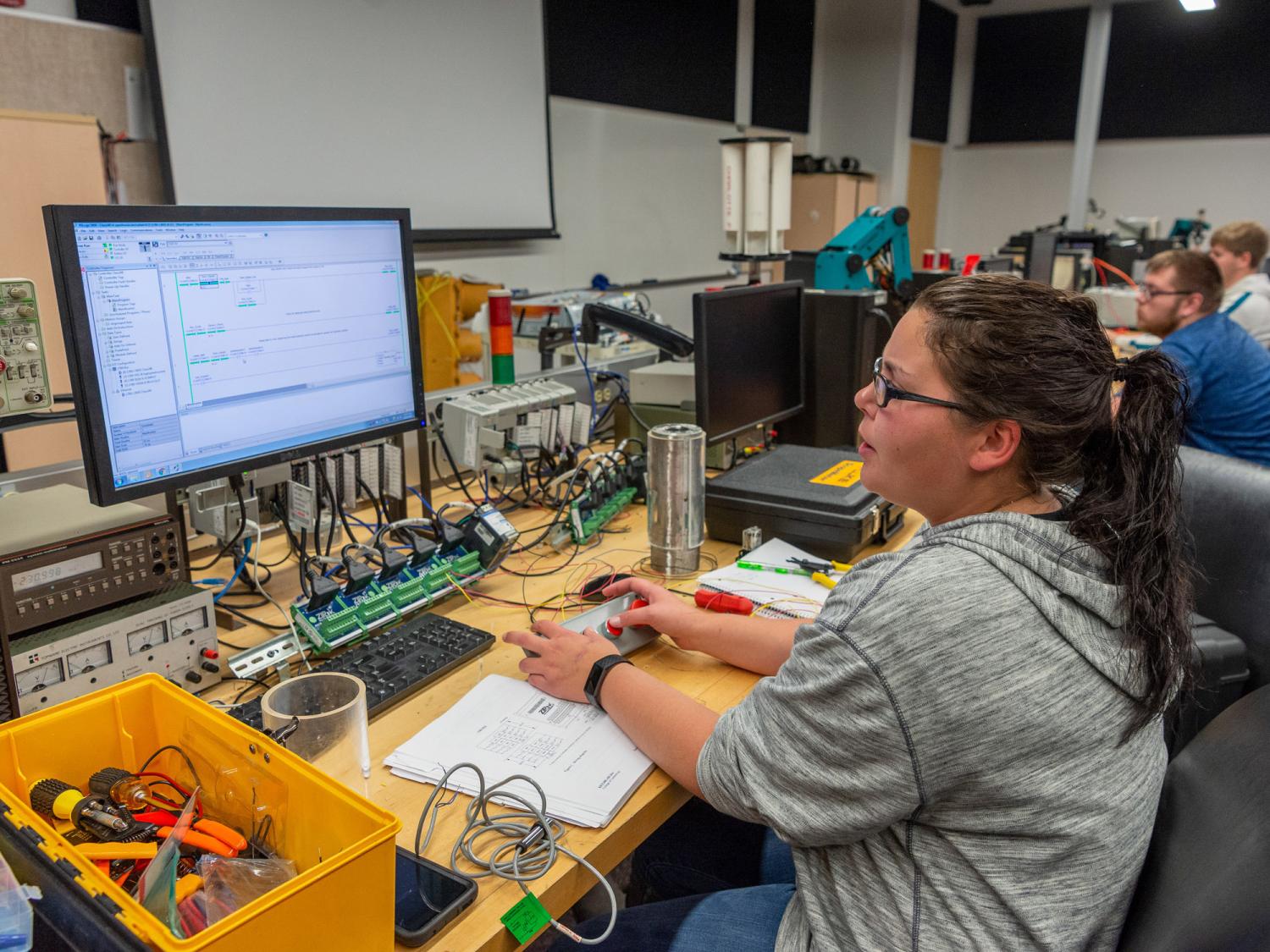 A student sitting in a lab looking at a computer screen