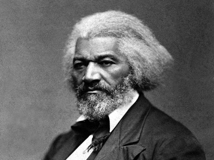 A man of color with a full head of hair and beard sits looking pensive in a portrait.